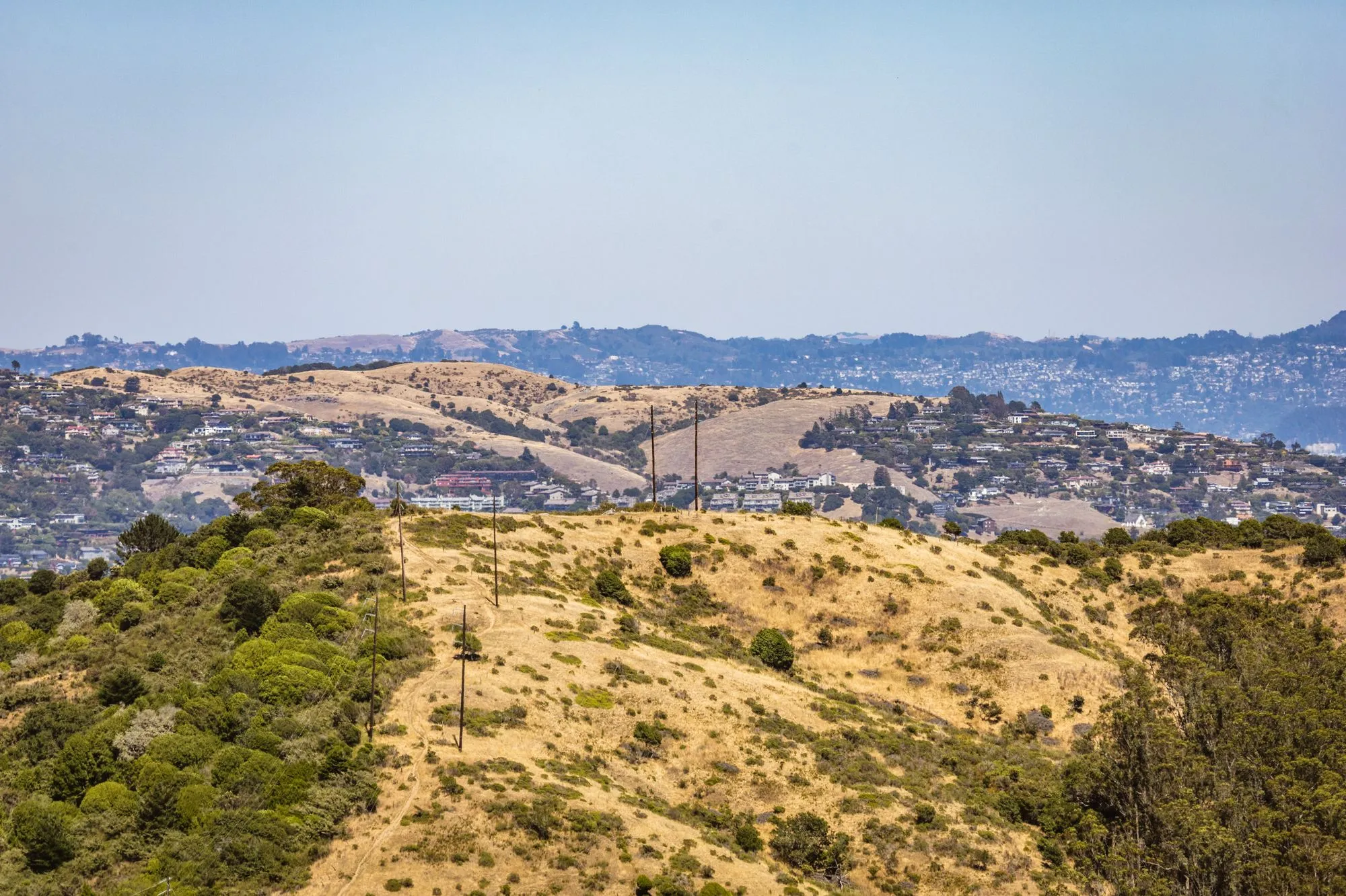 Golden rolling hills with homes spread across the valley below
