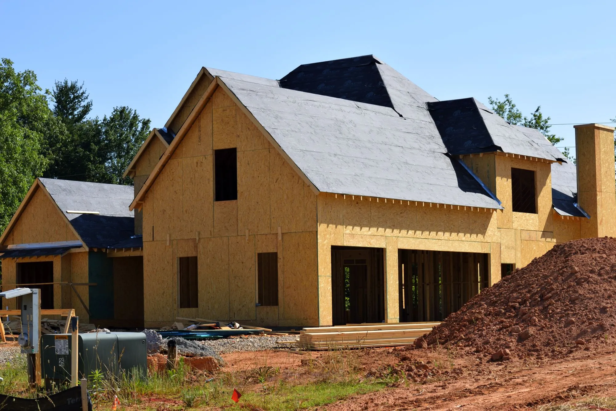 Two story house under construction with fresh dirt around the foundation