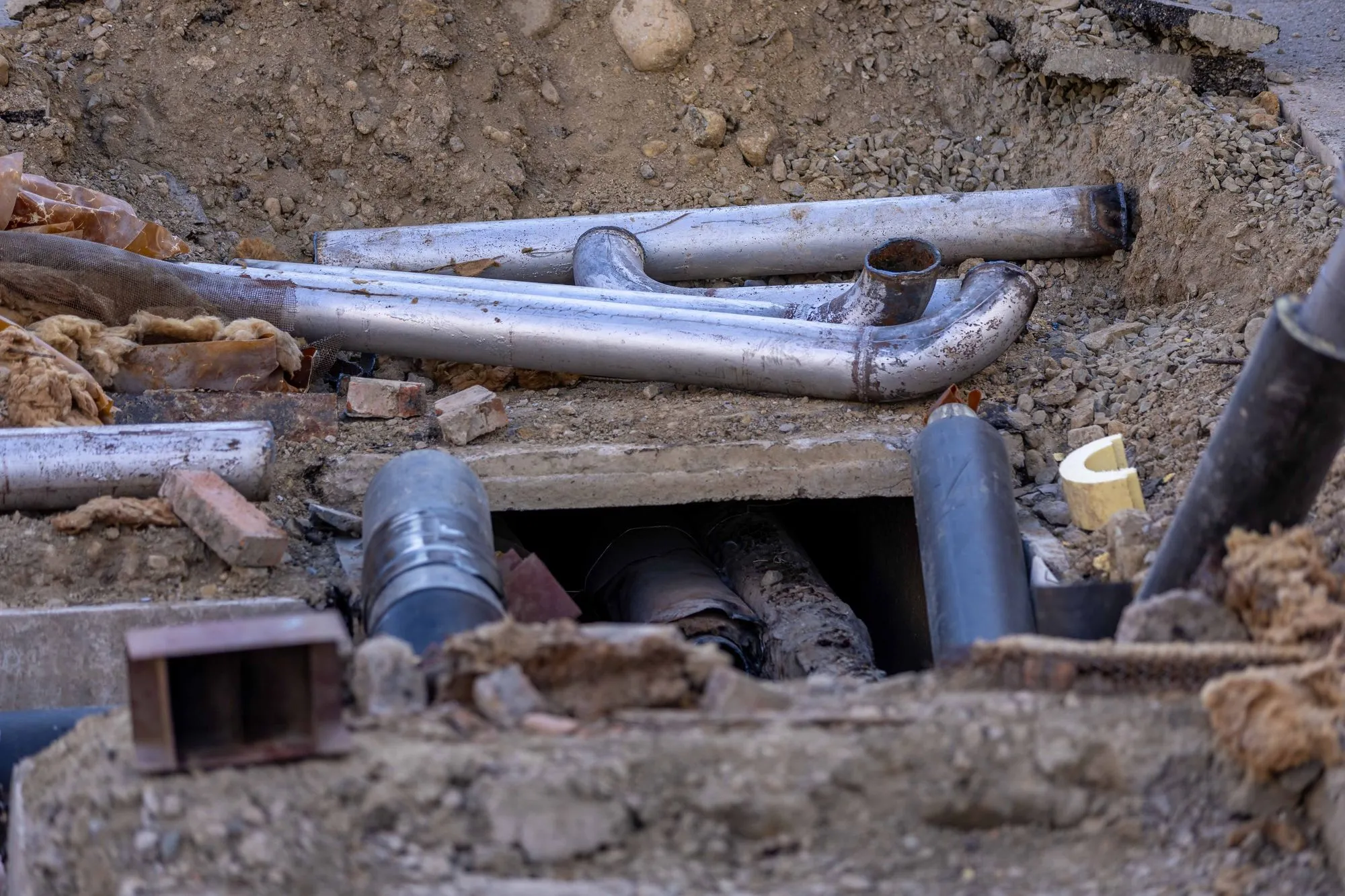 Close view of underground pipes exposed in an excavation